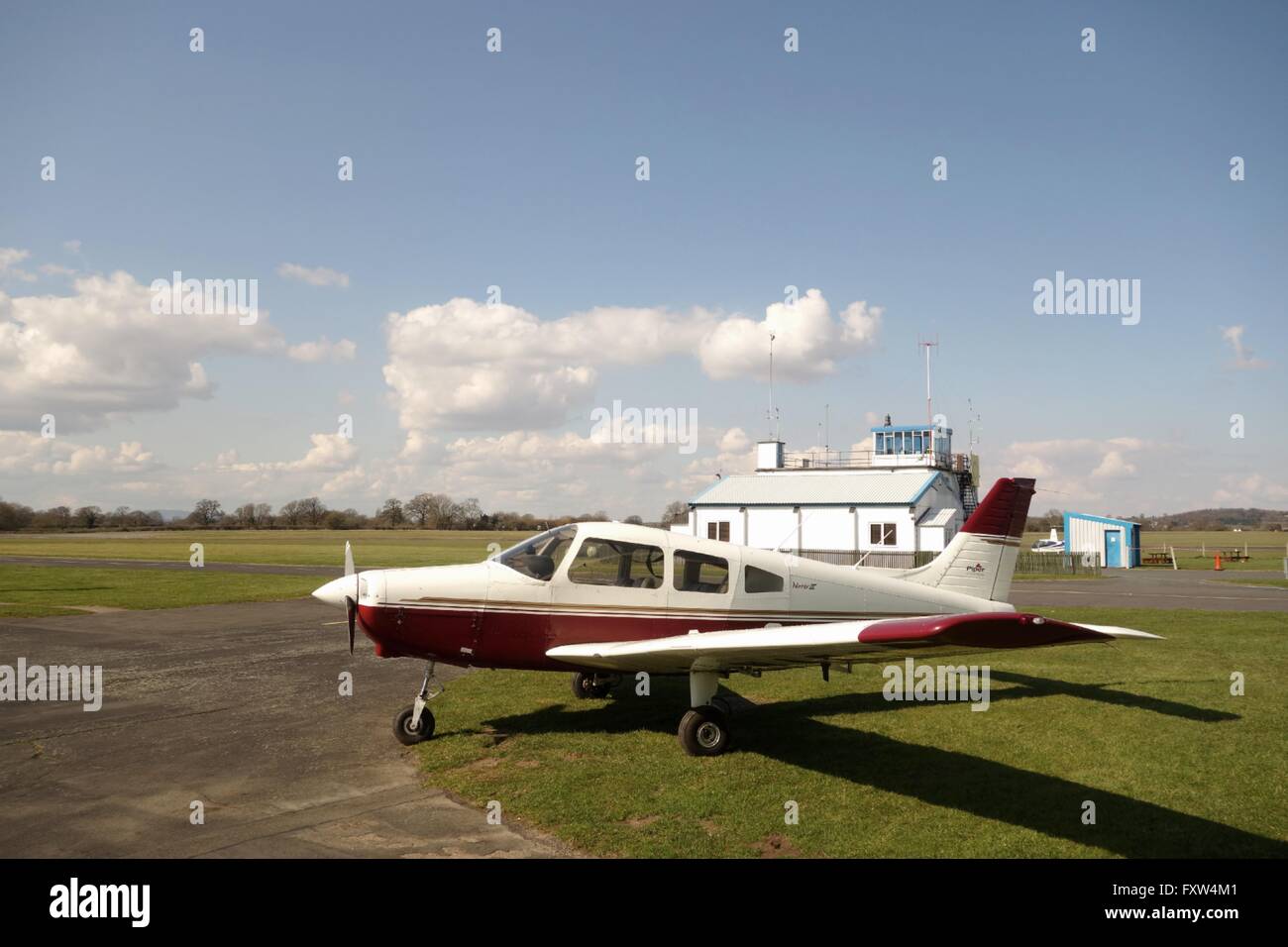 Light aircraft parked at Wolverhampton Halfpenny Green Aiirport, with control tower in background. Staffordshire. UK Stock Photo