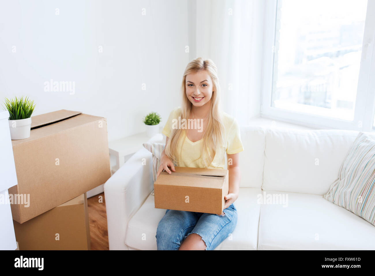 smiling young woman with cardboard box at home Stock Photo - Alamy