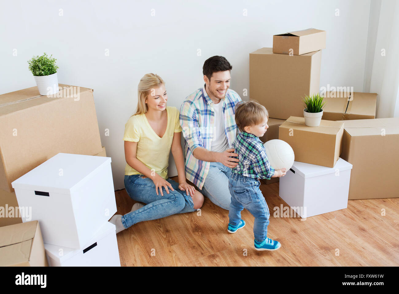 happy family moving to new home and playing ball Stock Photo - Alamy