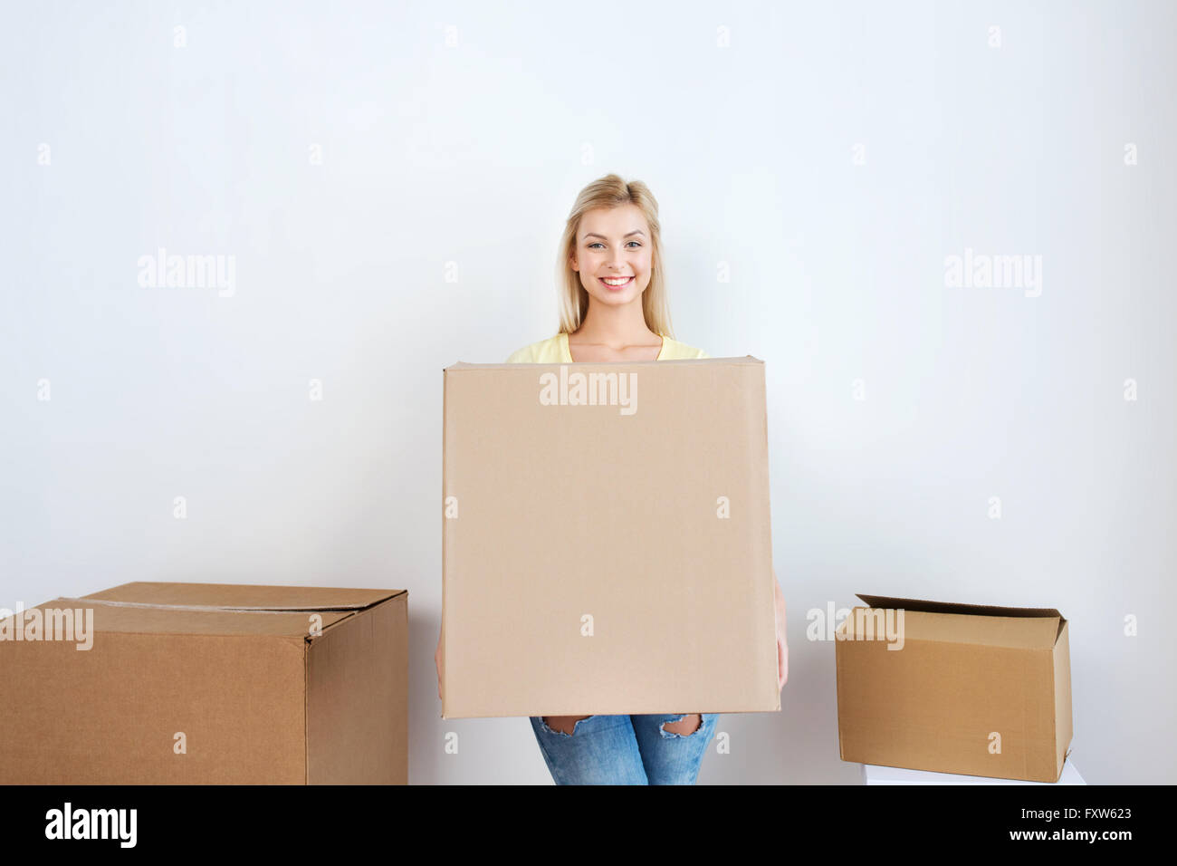 smiling young woman with cardboard box at home Stock Photo - Alamy
