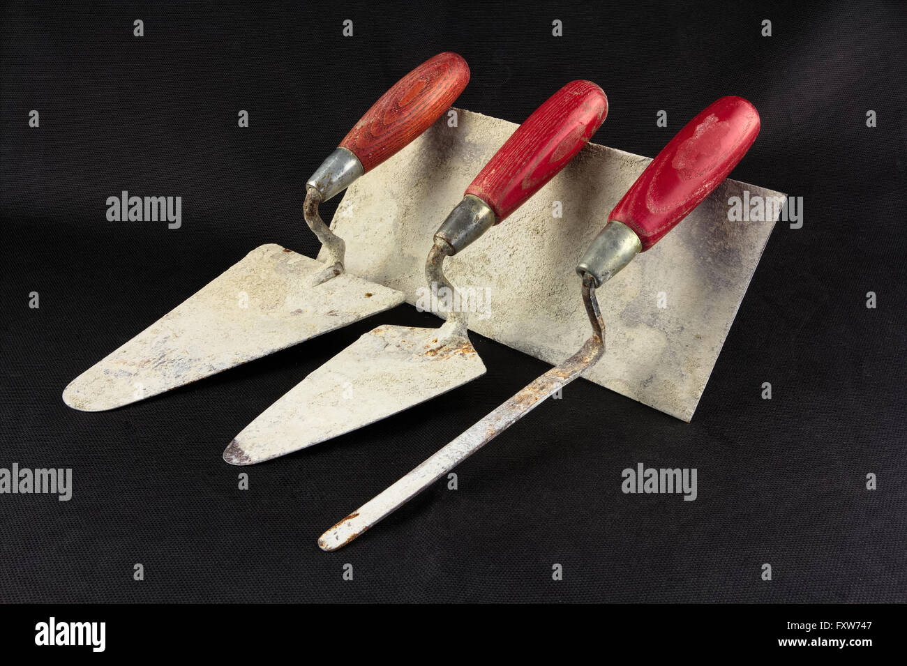 Dirty masonry tools on a black surface Stock Photo