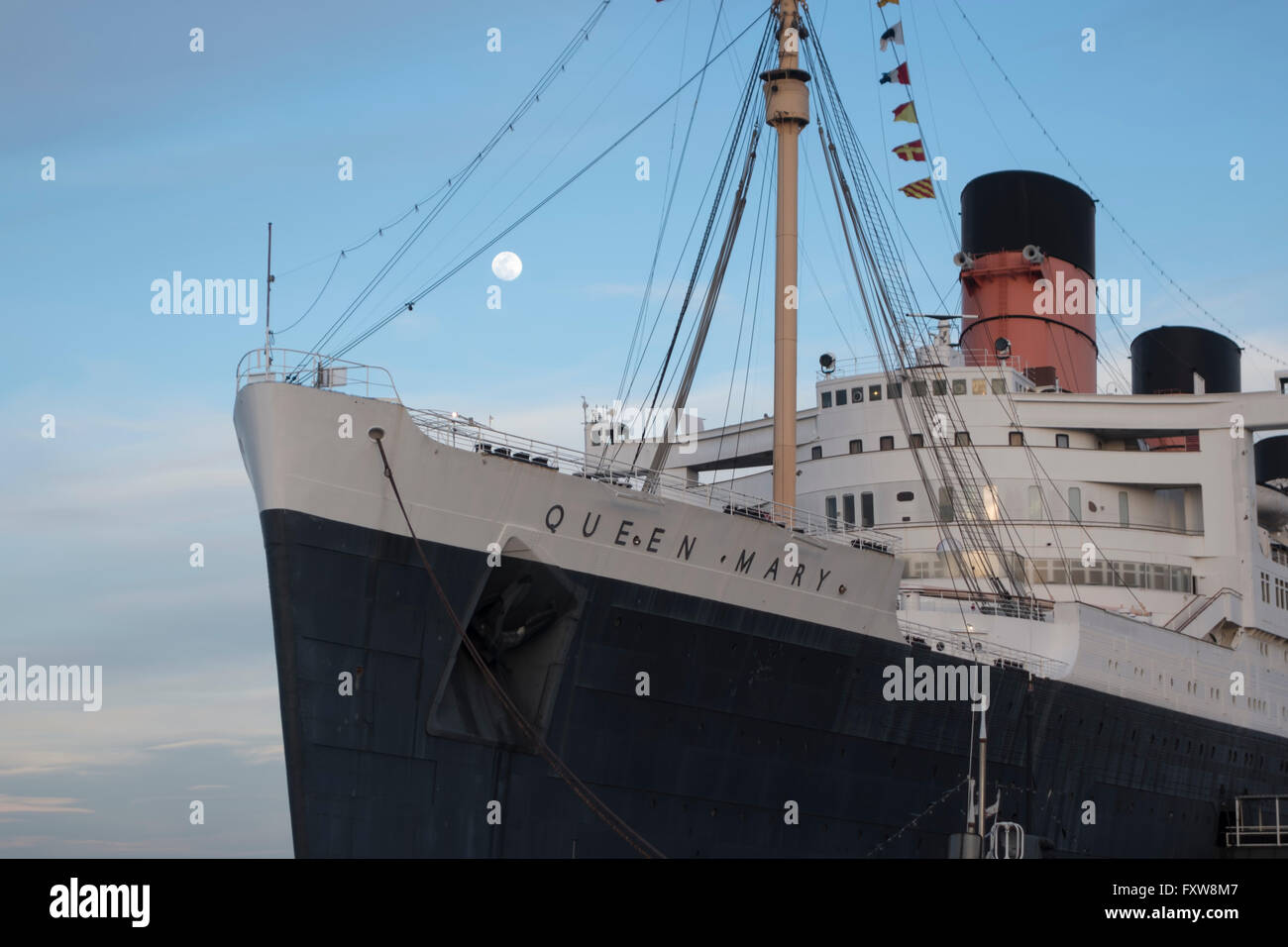 The Queen Mary liner docked at Longbeach California with the moon behind at sunset Stock Photo
