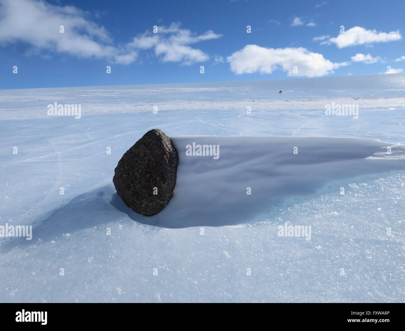 A meteorite sits on the blue ice field in the Miller Range December 19, 2015 in Antarctica. Scientists collected 570 meteorite samples during a two-month expedition as part of the Antarctic Search for Meteorites program. Stock Photo