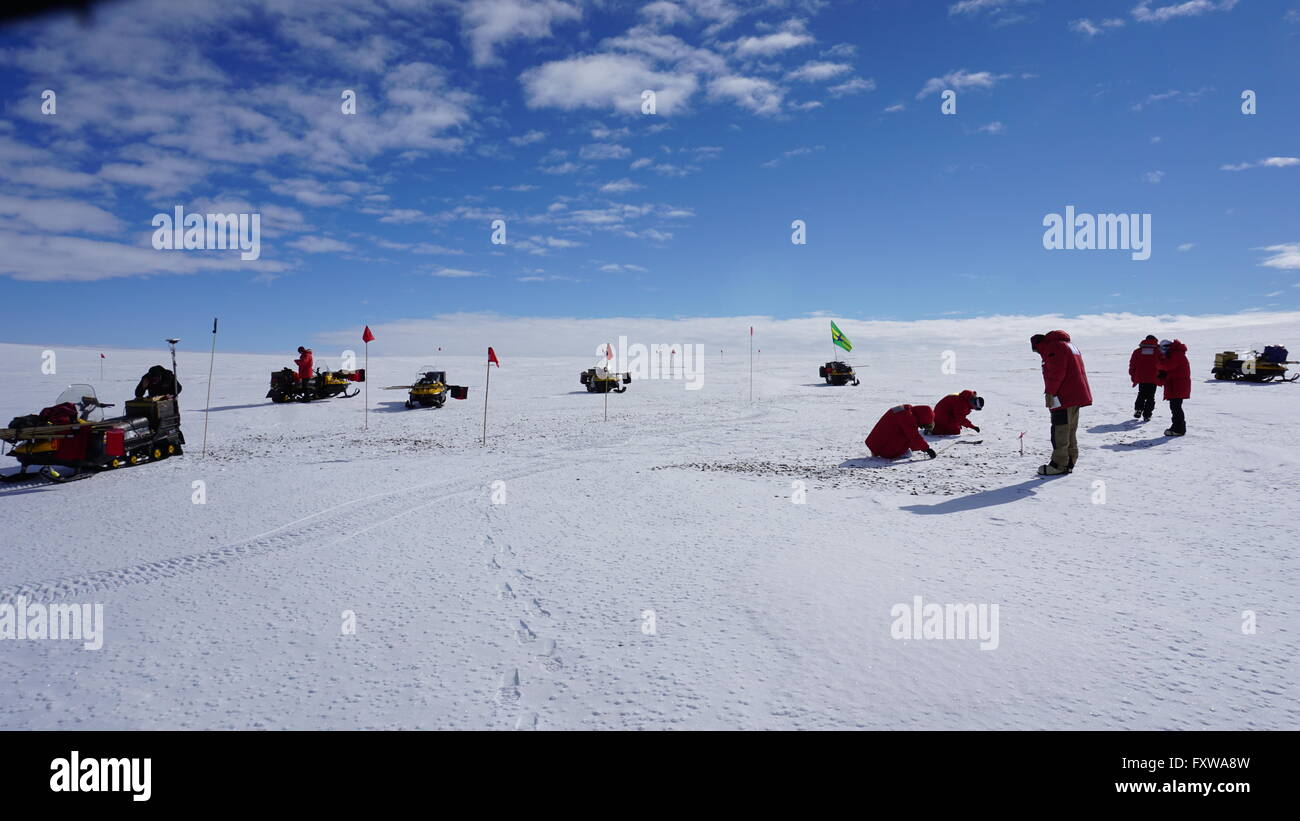 Researchers spread out across the blue ice field in the Miller Range in search of meteorites December 24, 2015 in Antarctica. Scientists collected 570 meteorite samples during a two-month expedition as part of the Antarctic Search for Meteorites program. Stock Photo