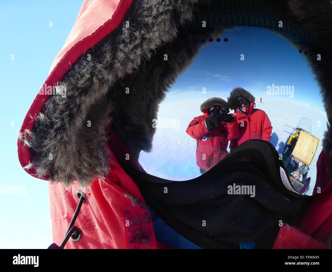 Researchers reflected in the mirror surface of snow goggles while searching for meteorites on the blue ice field in the Miller Range December 31, 2015 in Antarctica. Scientists collected 570 meteorite samples during a two-month expedition as part of the Antarctic Search for Meteorites program. Stock Photo