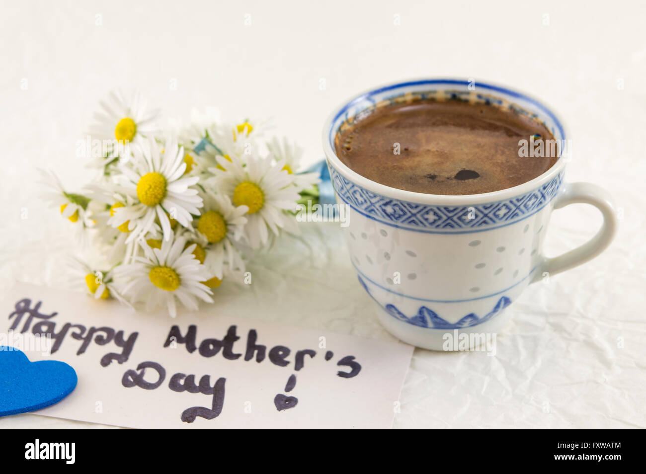 Happy mothers day note with cup of coffee and chamomile bouquet Stock Photo