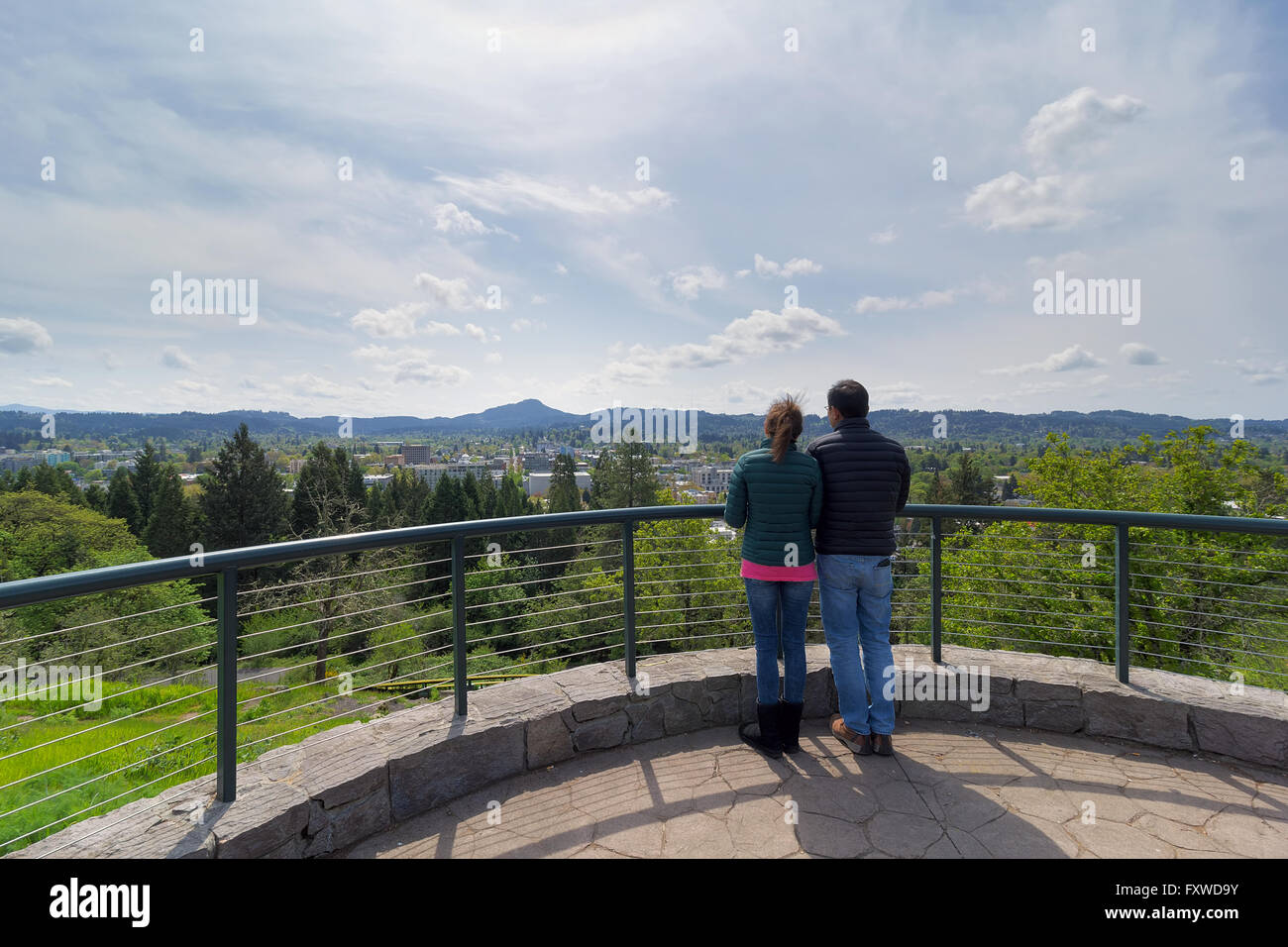 Couple at top of Skinner Butte Park viewing deck enjoying view of downtown Eugene Oregon on a beautiful day Stock Photo