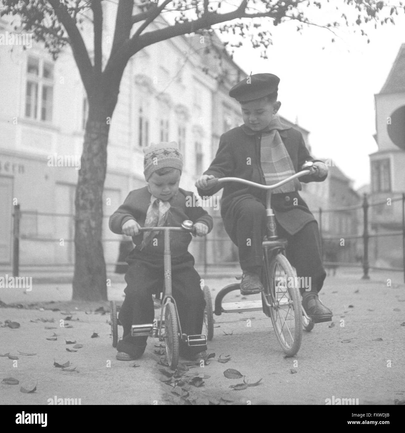 Zwei Buben auf ihren Dreirädern Stock Photo