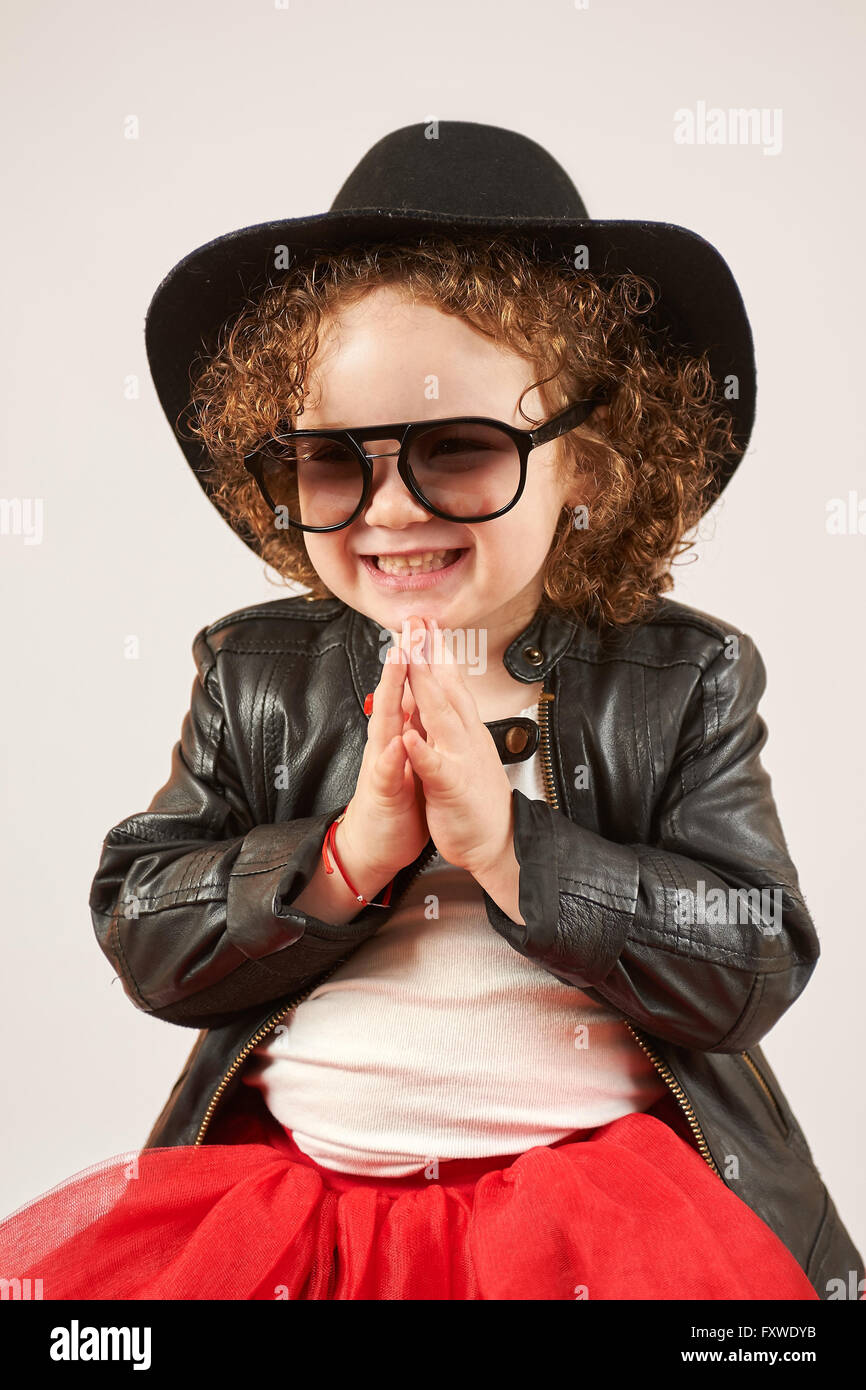 Little girl with black hat and Sunglasses sitting and smiling Stock ...