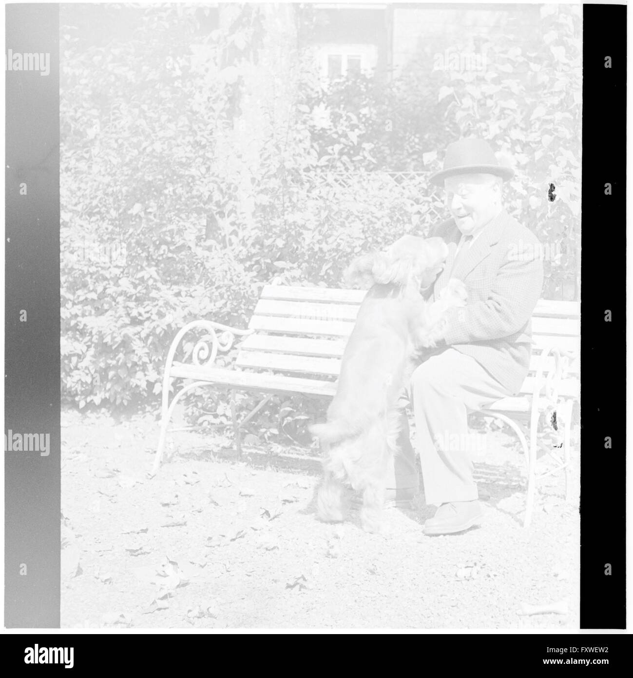 Thimig sitzt auf einer Bank, mit seinem Hund ... Stock Photo