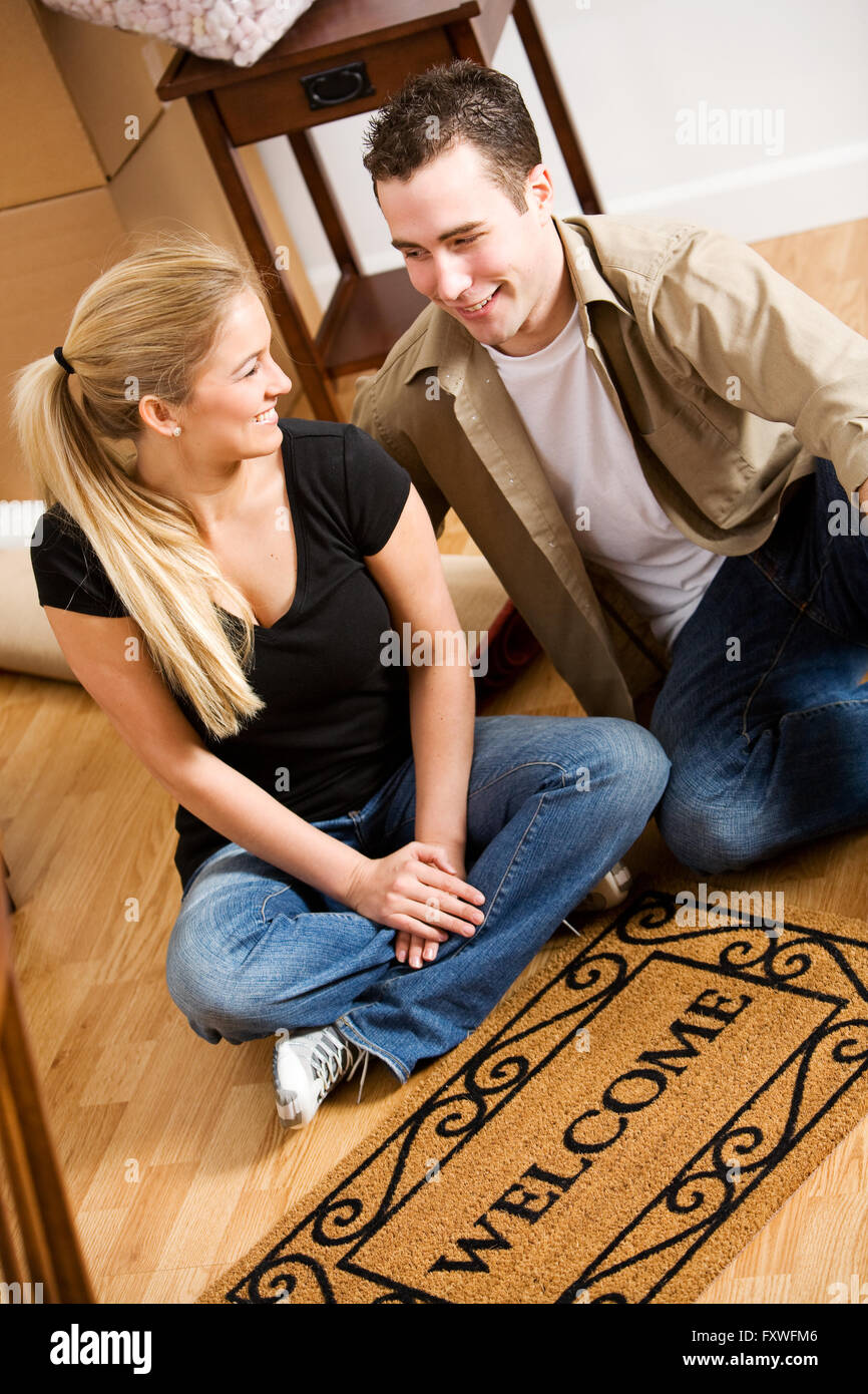 Young couple, indoors, packing posessions in cardboard boxes. Stock Photo