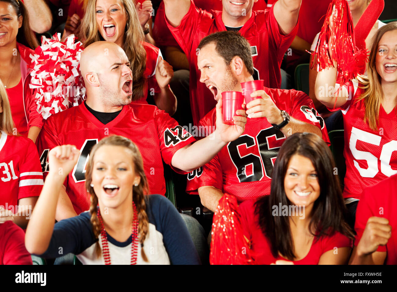 Multi-ethnic crowd of American football fans in a stadium, cheering