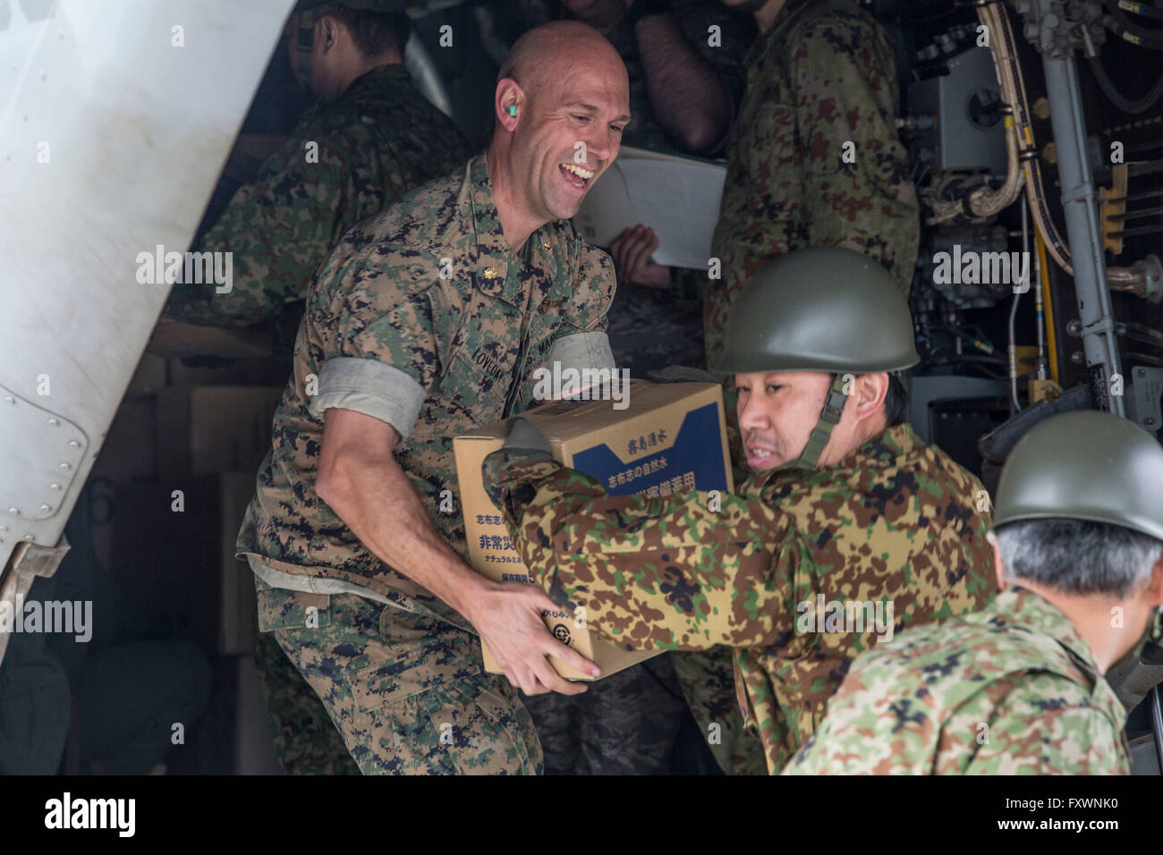 U.S Marines assist Japanese Self-Defense soldiers with unloading humanitarian aid for those affected by recent earthquakes in Kumamoto April 18, 2016 Takayubaru, Japan. The U.S joined thousands of Japanese troops to help victims of two massive earthquakes that struck the Kyushu region. Stock Photo