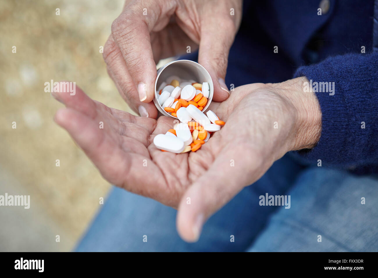 Woman dispensing pills from pill bottle into hand Stock Photo