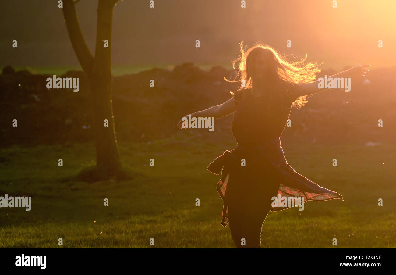 Teen girl jump against beautiful sunset in forest Stock Photo