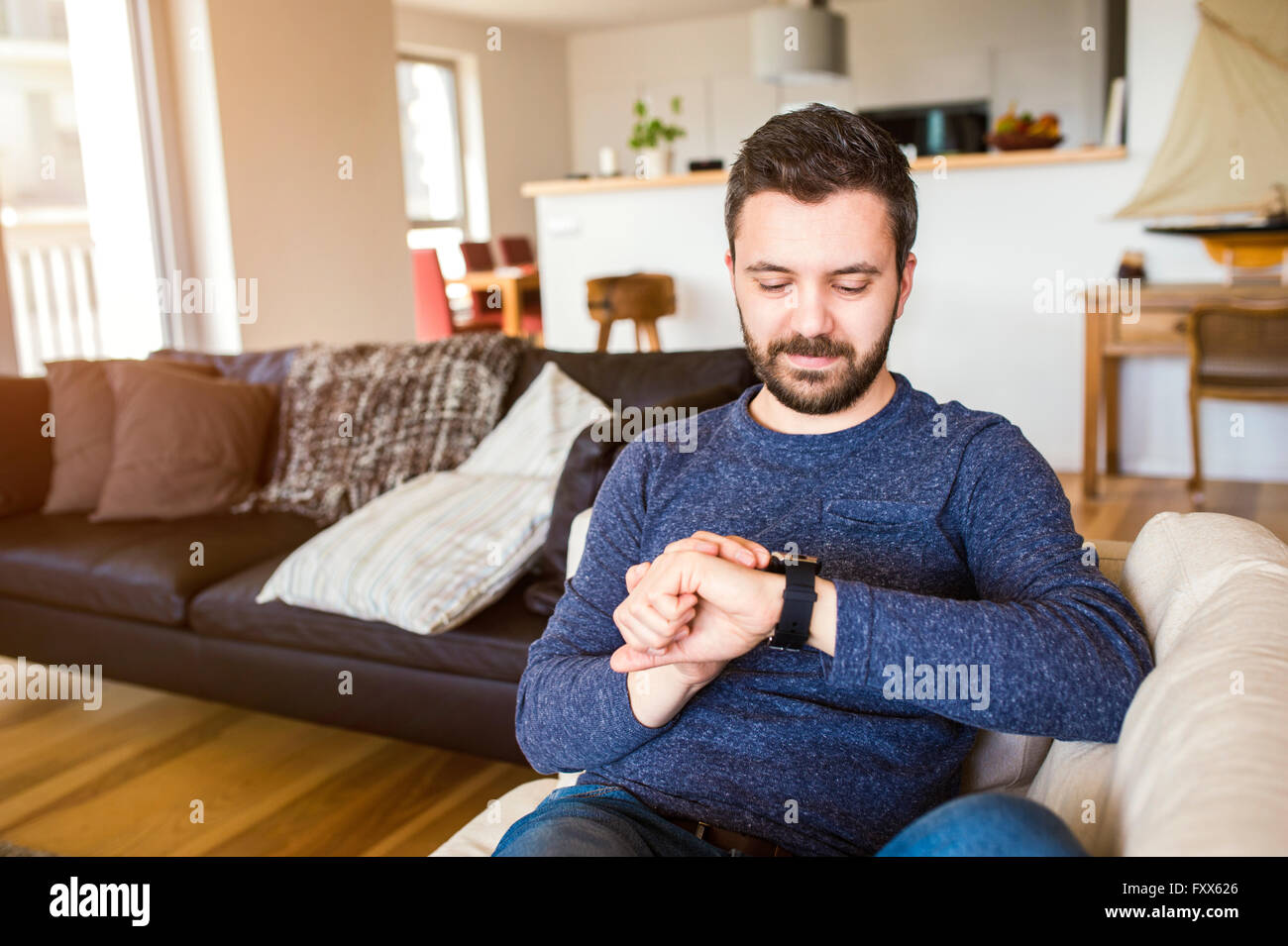 Man working from home using smart watch, living room Stock Photo