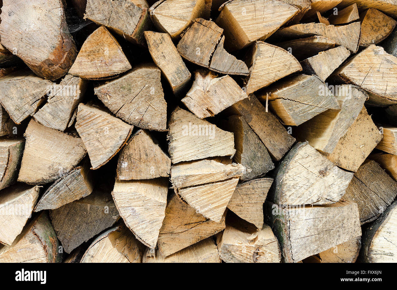 Background of stacked conducting firewood chopped. Close-up. Stock Photo