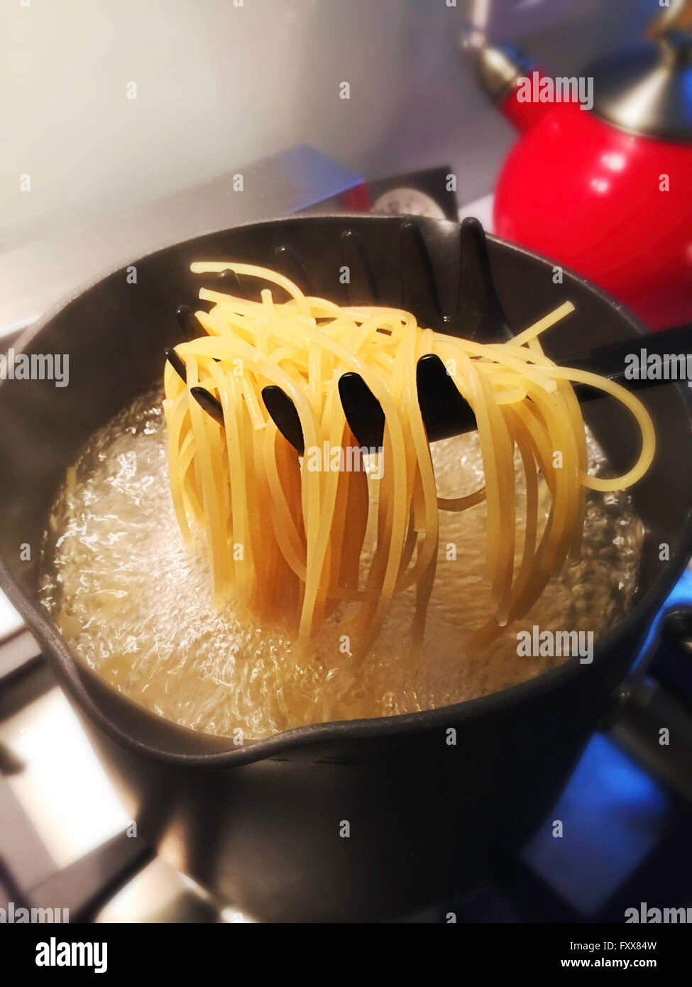 Boiling Water Cooking Pasta on Stove in Residential Kitchen Stock Photo
