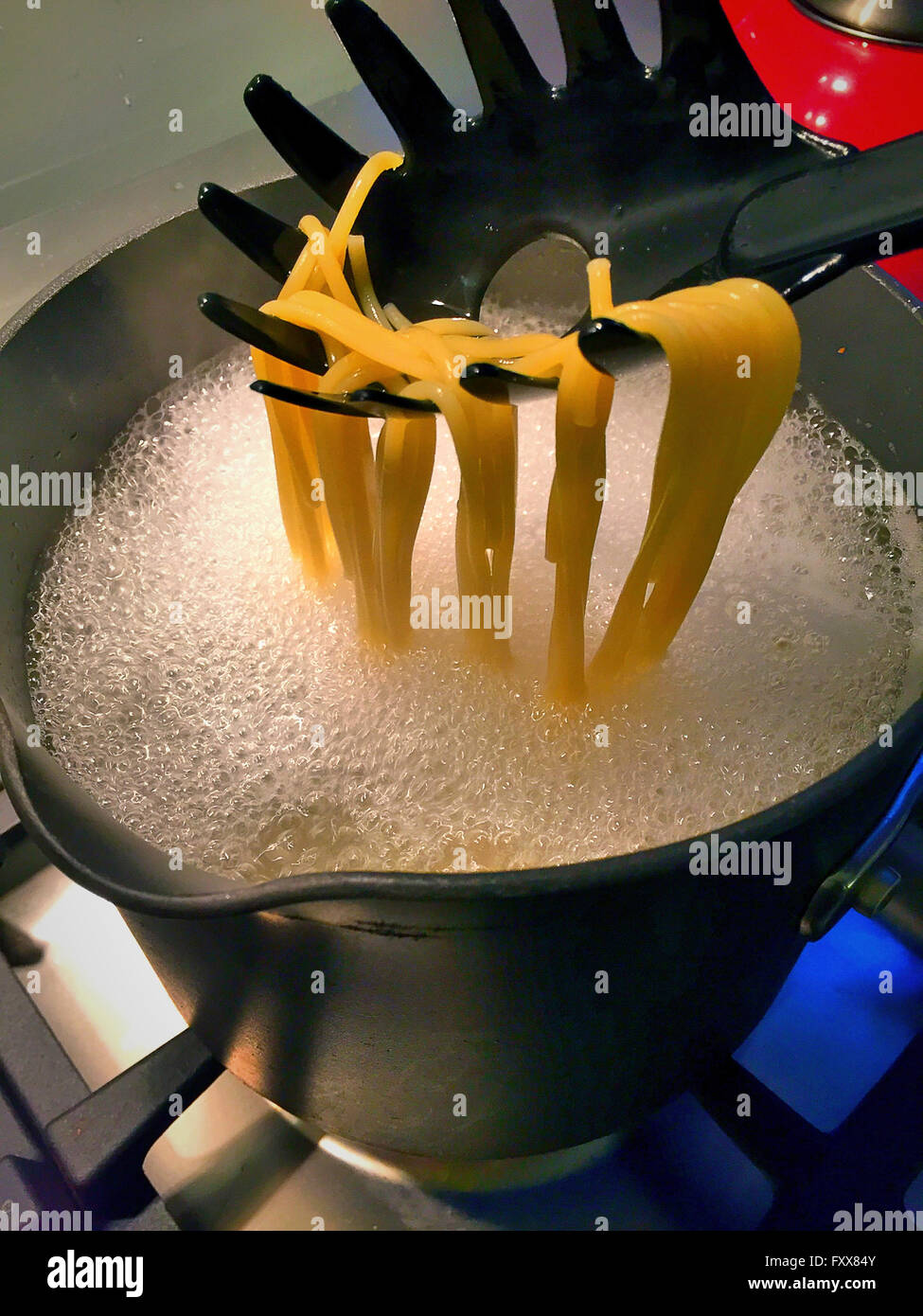 Boiling Water Cooking Pasta on Stove in Residential Kitchen Stock Photo