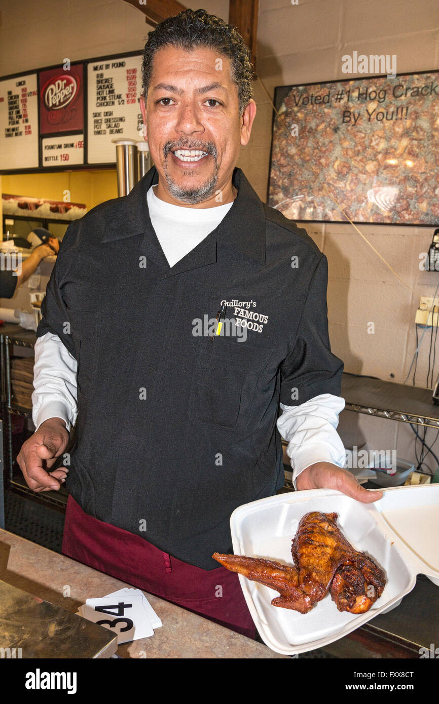 Darby Guillory holds one of his huge, a freshly cooked BBQ turkey wings. Stock Photo