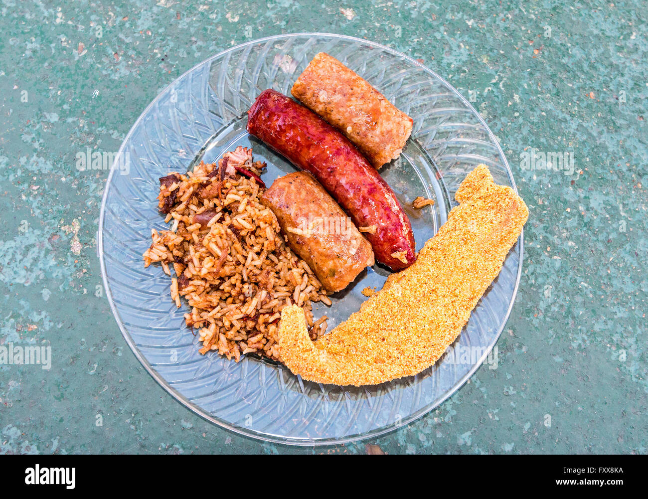 Plate of Cajun food including fried catfish, sausage, boudin, cracklins