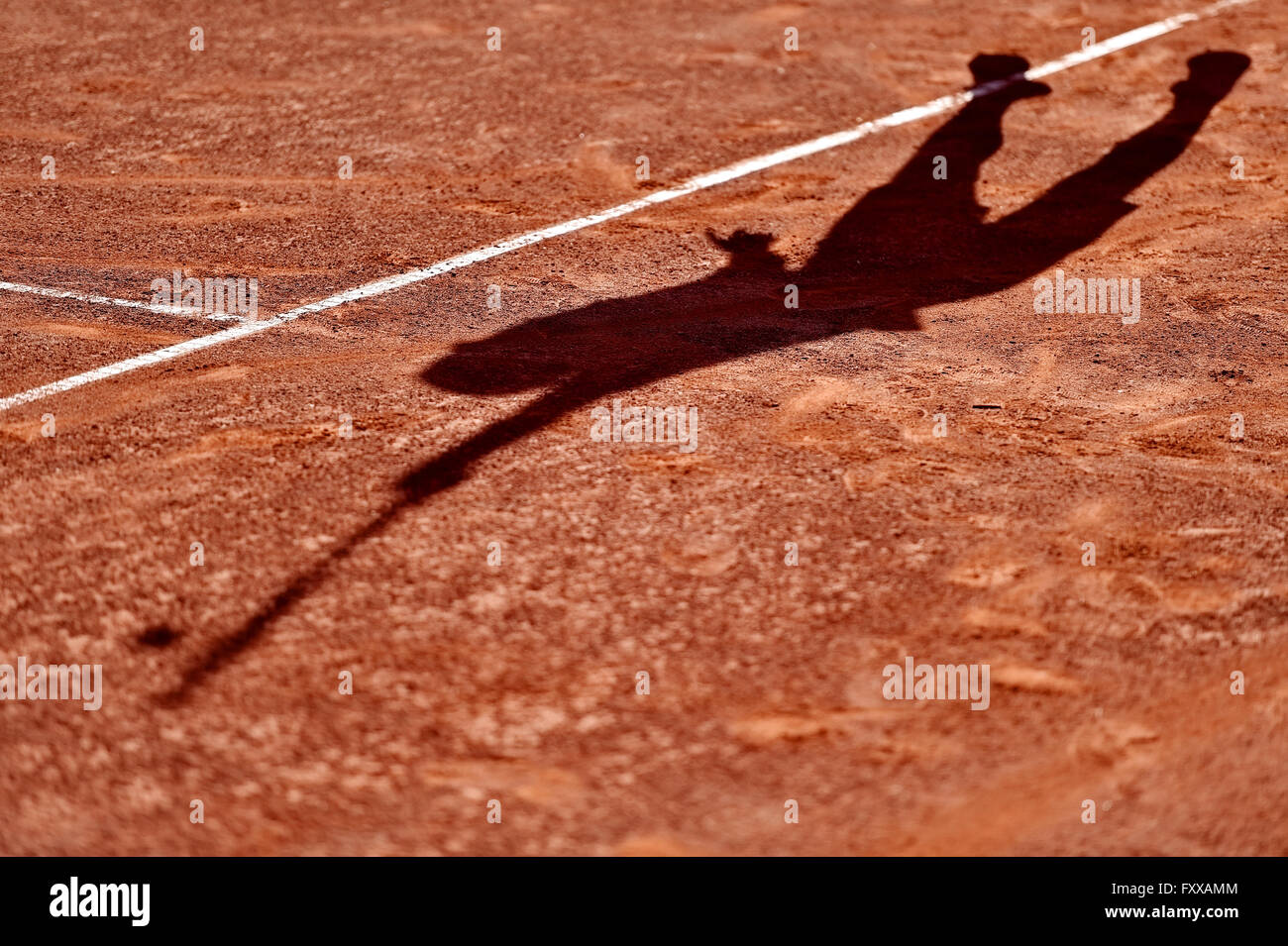 Shadow of a tennis player in action on a clay court Stock Photo