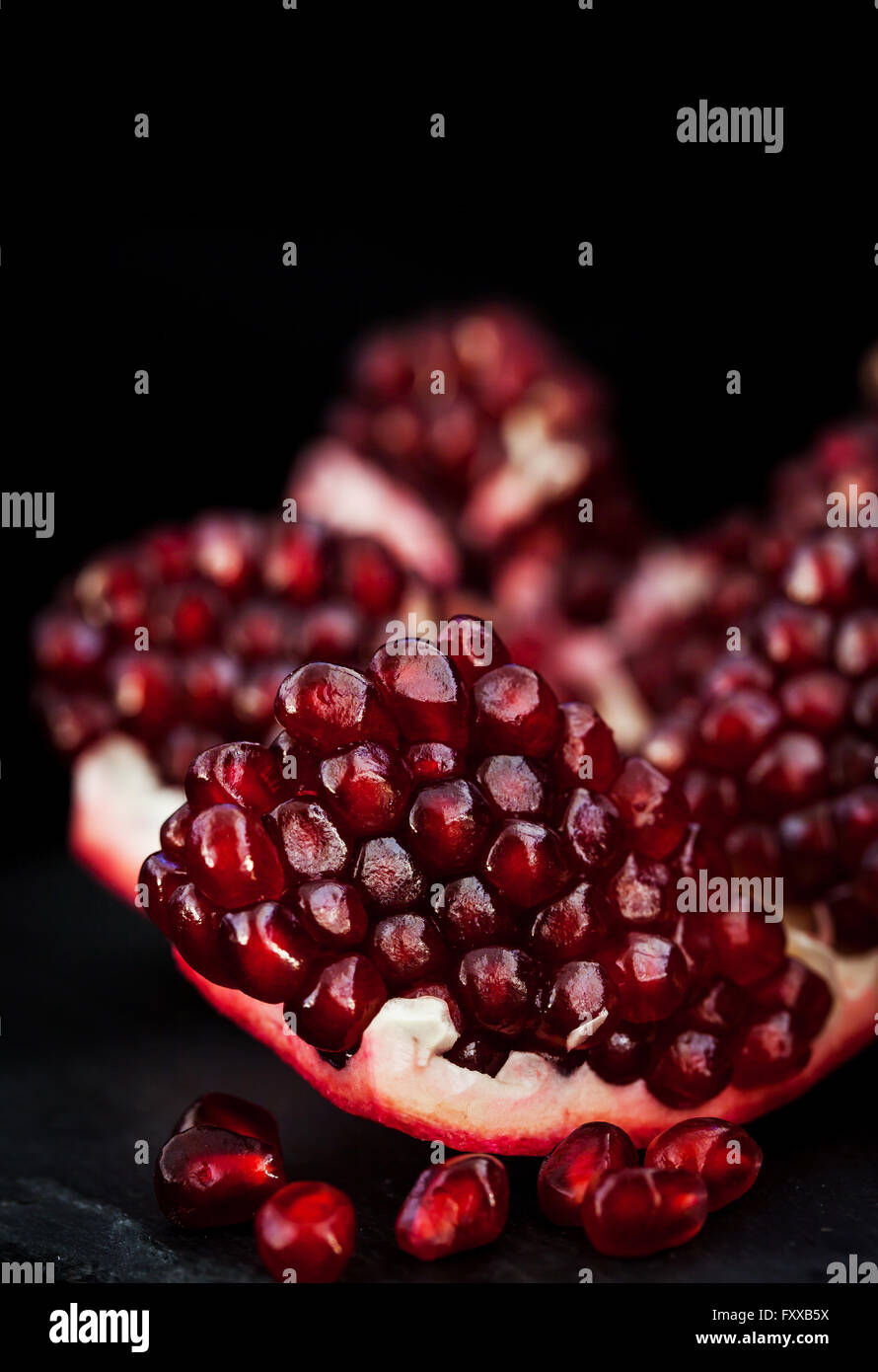 Fresh pomegranate and seeds on black background Stock Photo