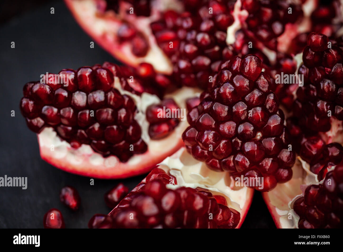 Fresh pomegranate and seeds on black background Stock Photo