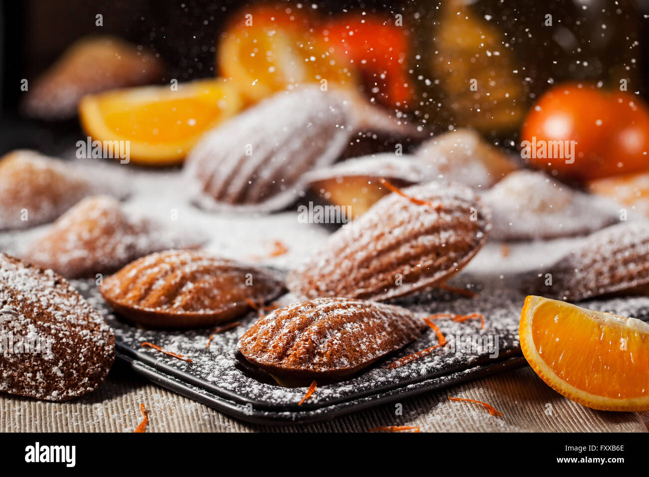 Homemade orange honey madeleines cookies and sugar powder motion Stock Photo