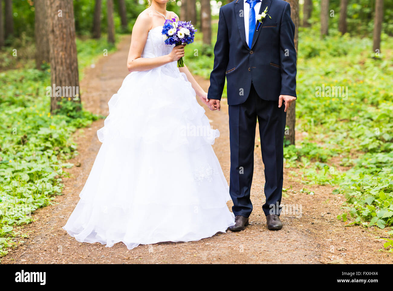 Bride and groom holding hands outdoors Stock Photo - Alamy