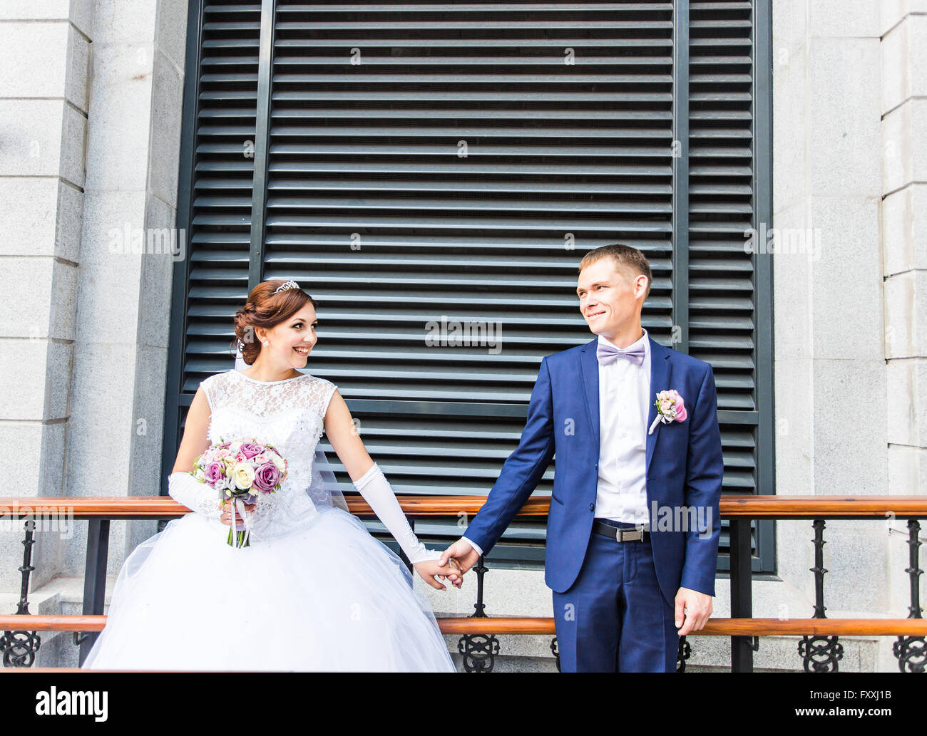 Bride and groom holding hands outdoors Stock Photo - Alamy