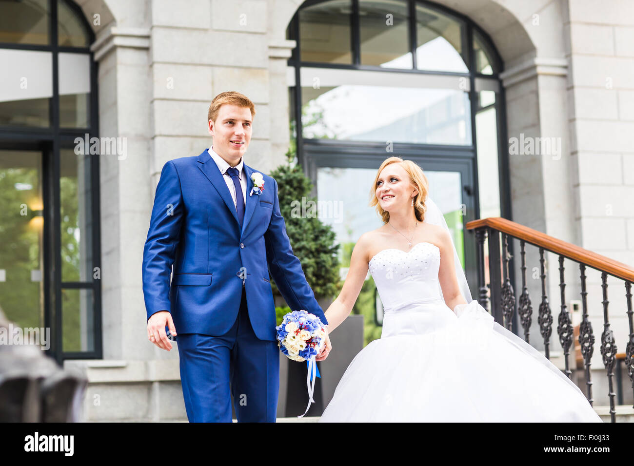 Bride and groom holding hands outdoors Stock Photo - Alamy