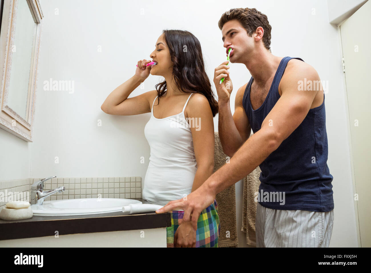 Couple brushing their teeth in bathroom Stock Photo