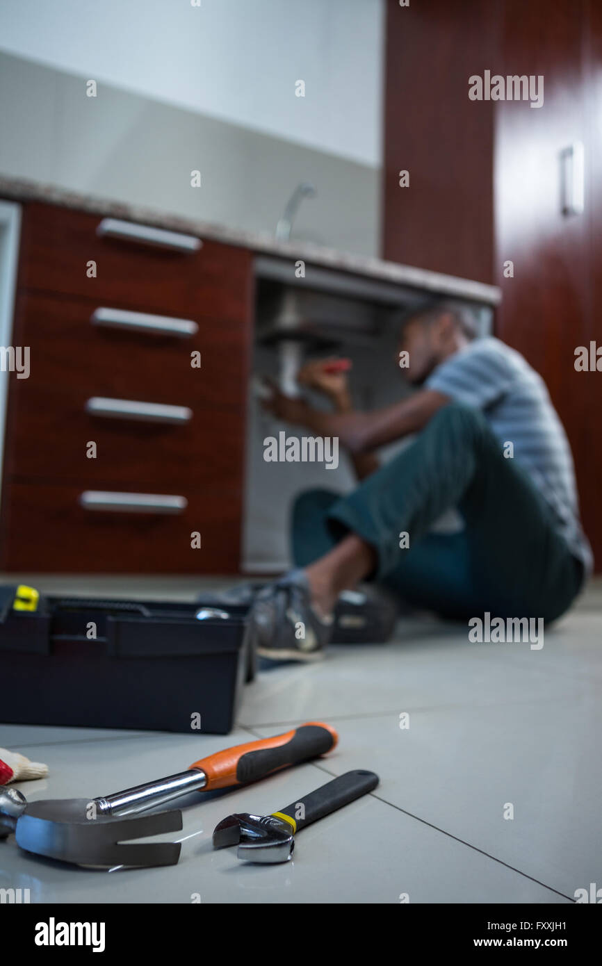 Plumber fixing under the sink with wrench Stock Photo Alamy