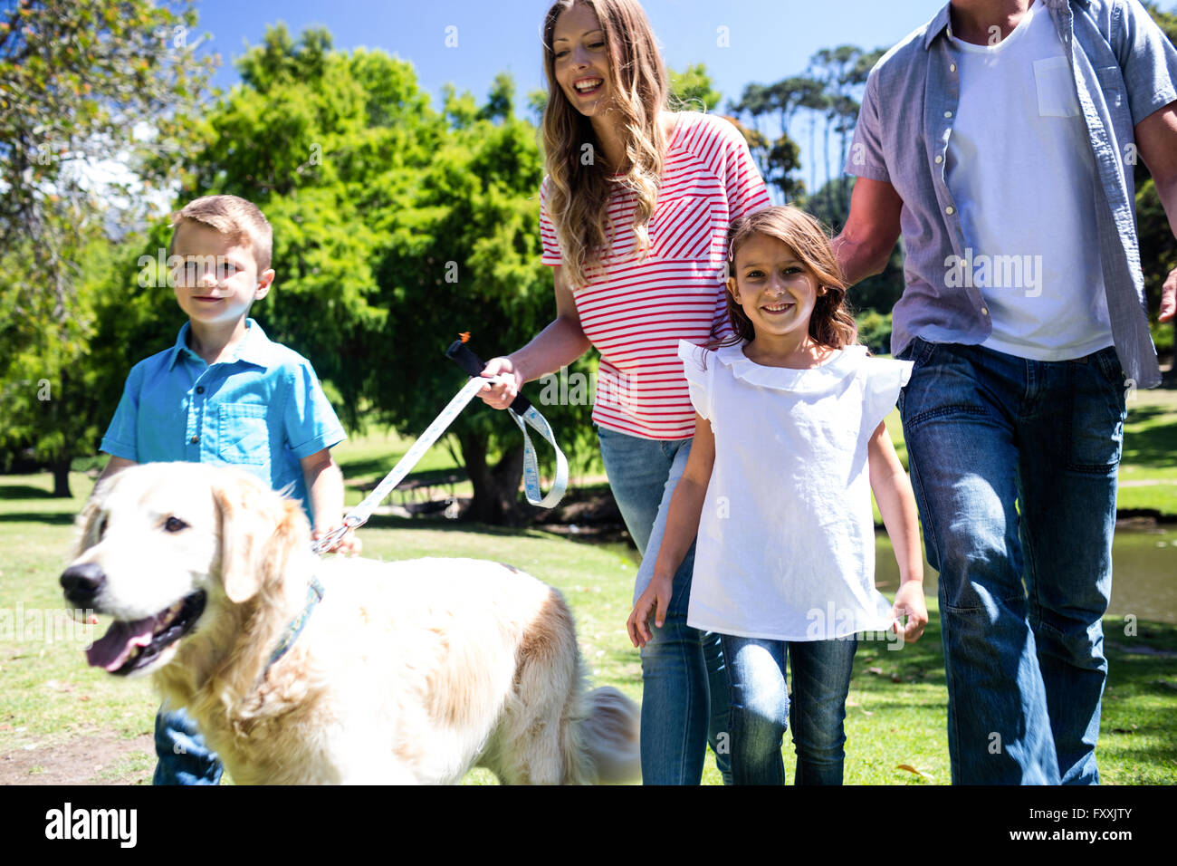 Family walking in the park with their dog Stock Photo
