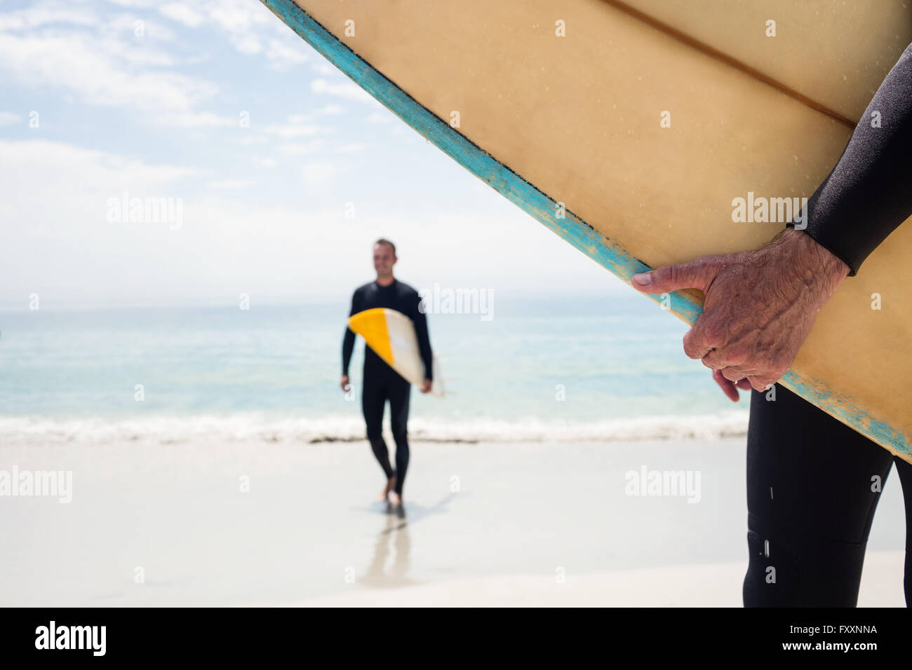 Man walking with surfboard on the beach Stock Photo - Alamy