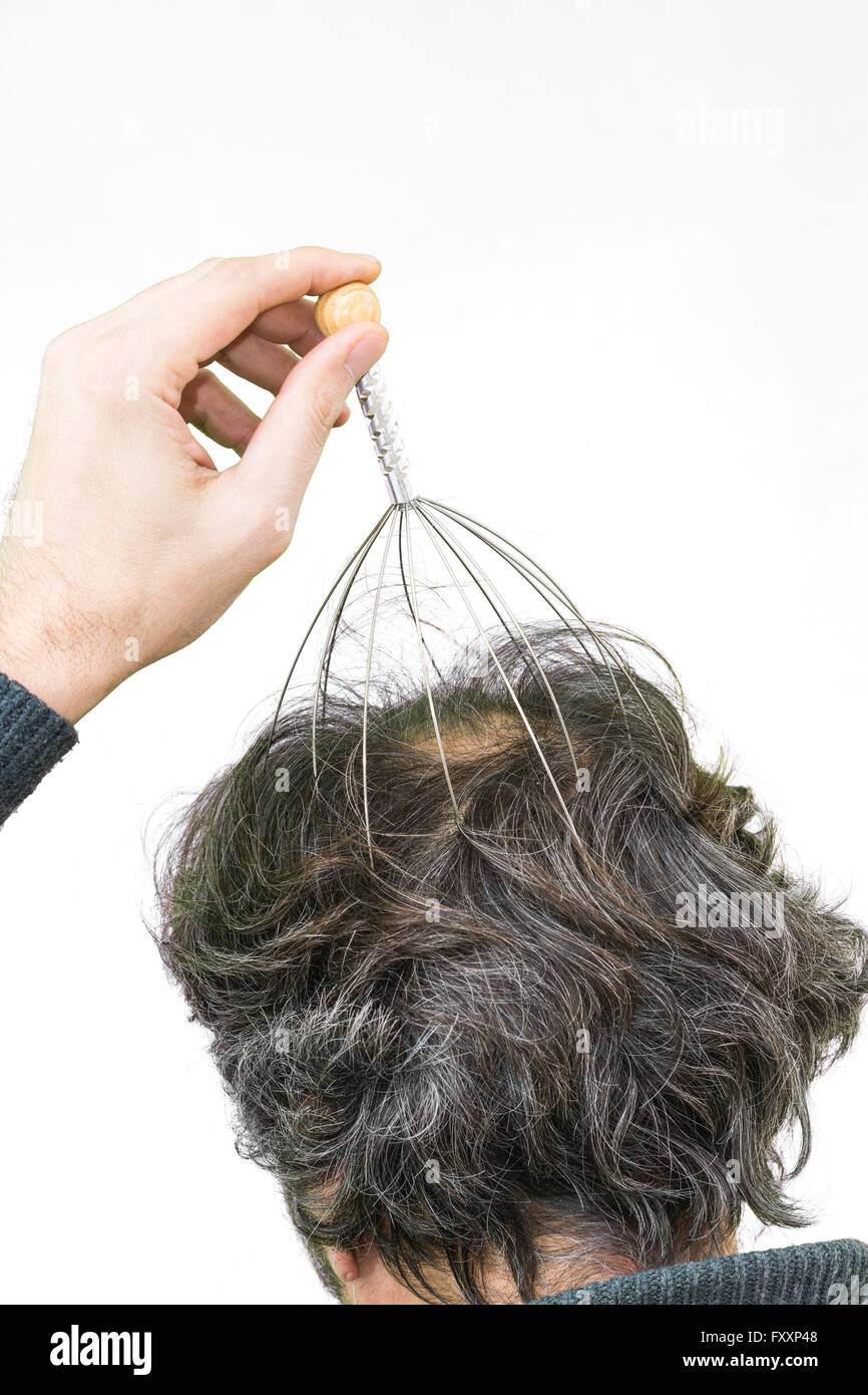 Man relaxes with the Genie head massager. Alternative Therapy. Indian