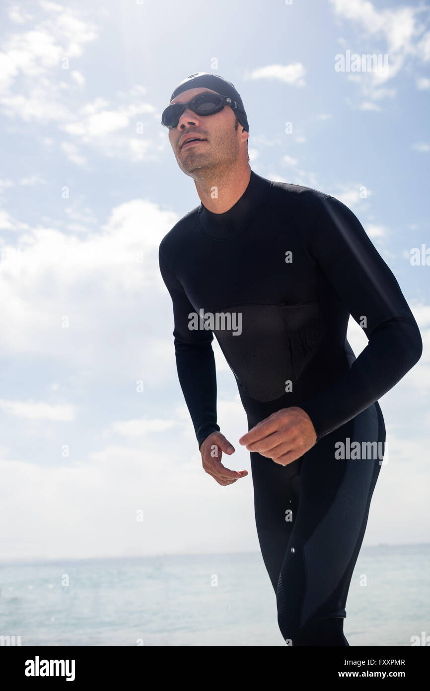 Young man in wetsuit ready to run on beach Stock Photo Alamy