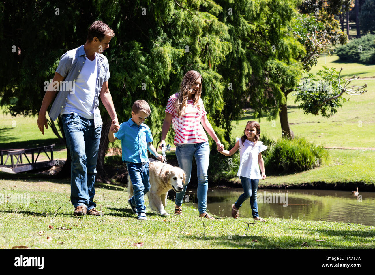 Family walking in the park with their dog Stock Photo