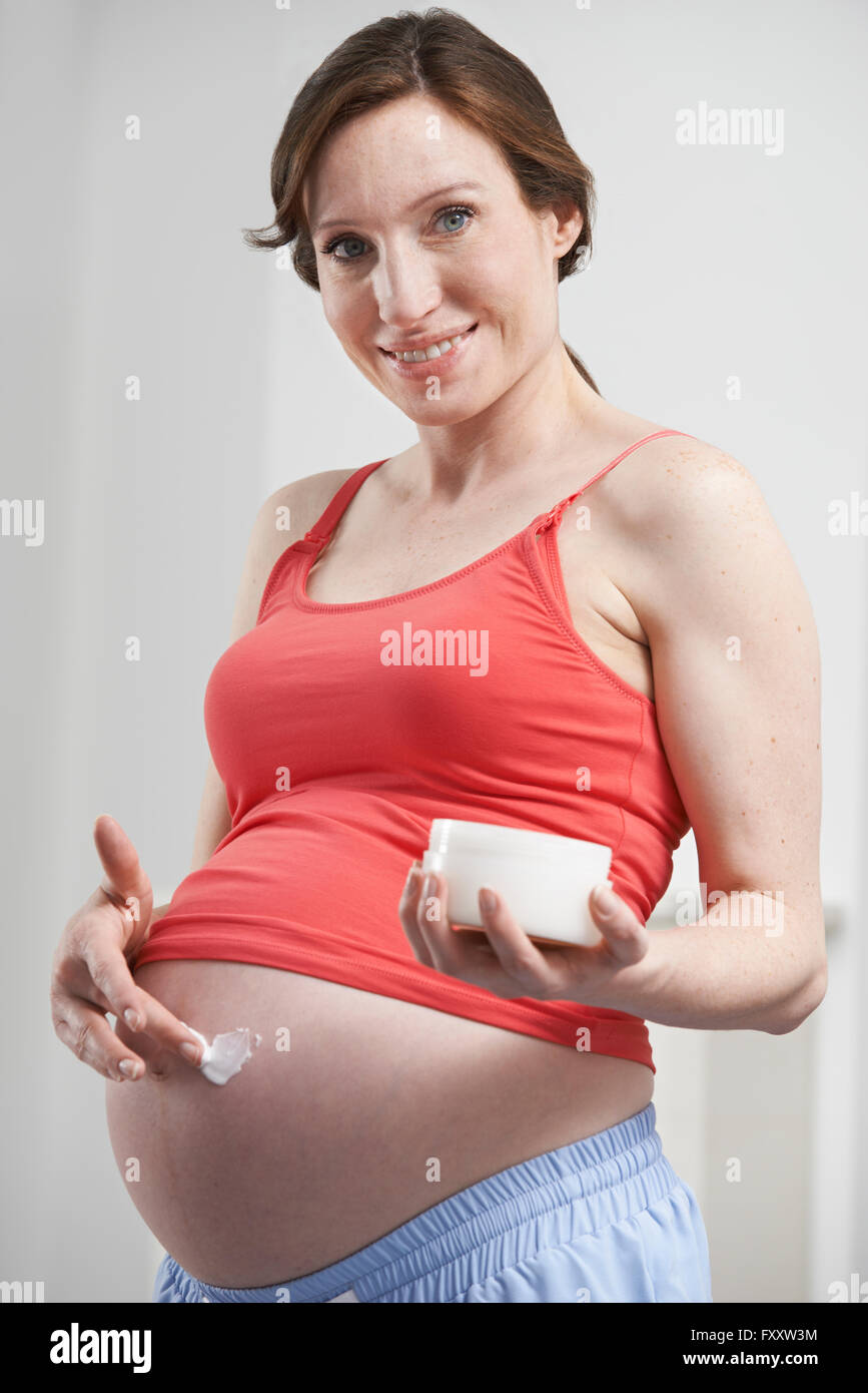 Pregnant Woman Moisturizing Belly Stock Photo