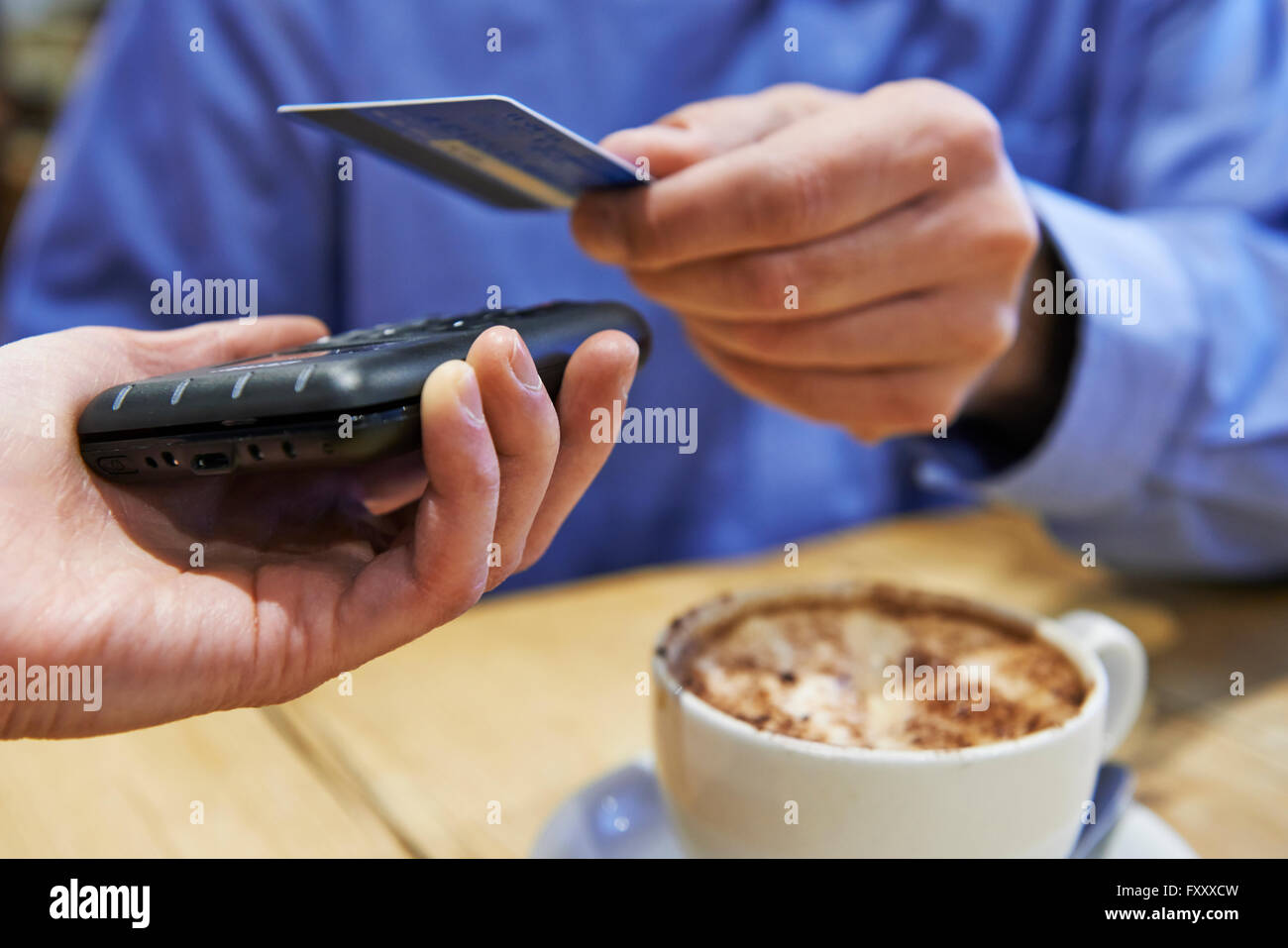 Customer Using Contactless Payment In Coffee Shop Stock Photo