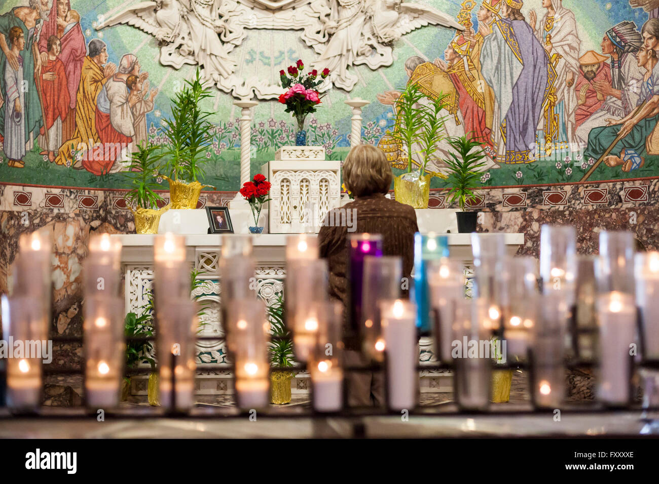 Detroit, Michigan - A woman prays at a shrine before mass begins at Holy Redeemer Catholic Church. Stock Photo