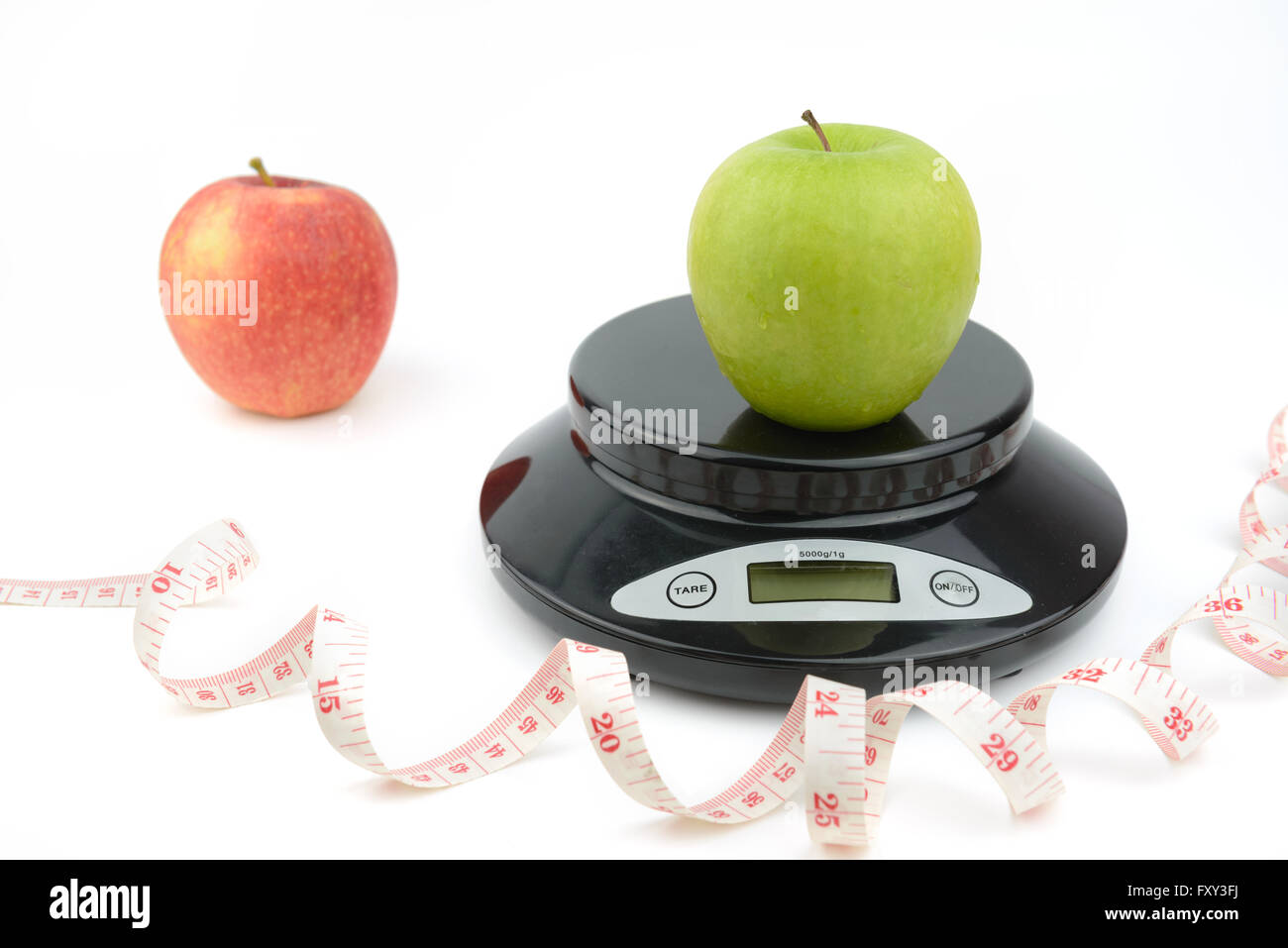 Black digital scale on isolate white background, with green apple, measurement tape Stock Photo