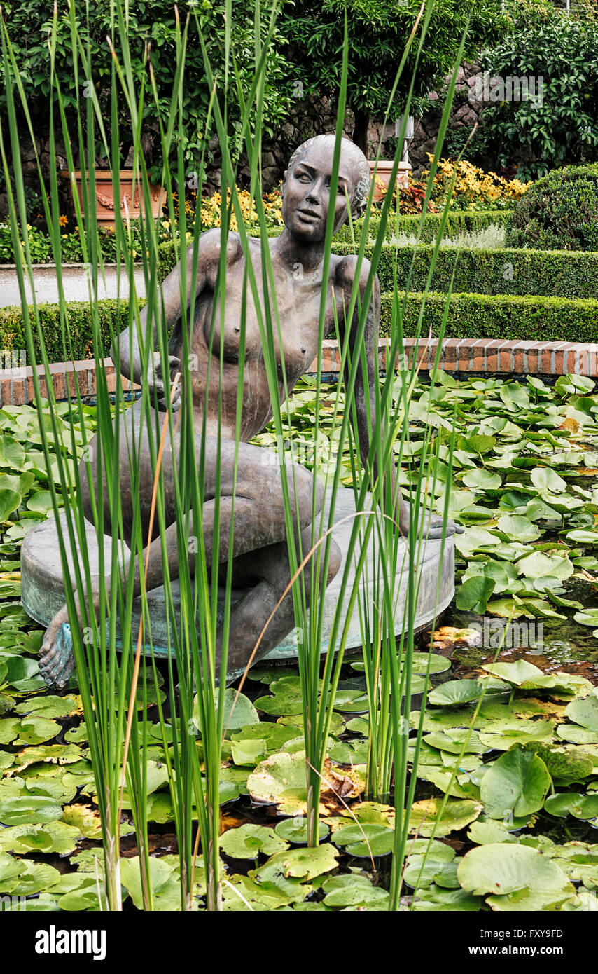 Landscape with woman sculpture in lily pond Stock Photo