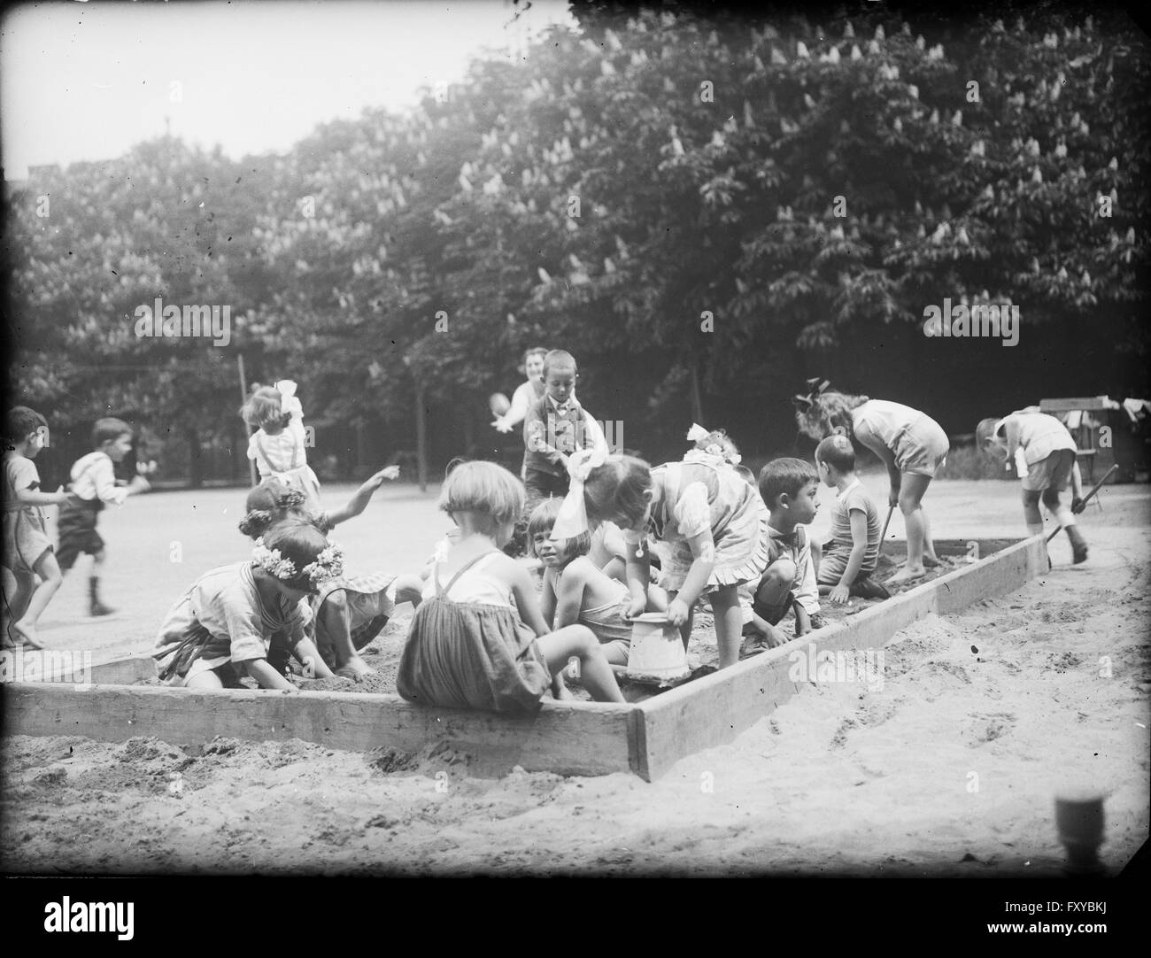 Spielende Kinder in der Sandkiste einer Parkanlage Stock Photo