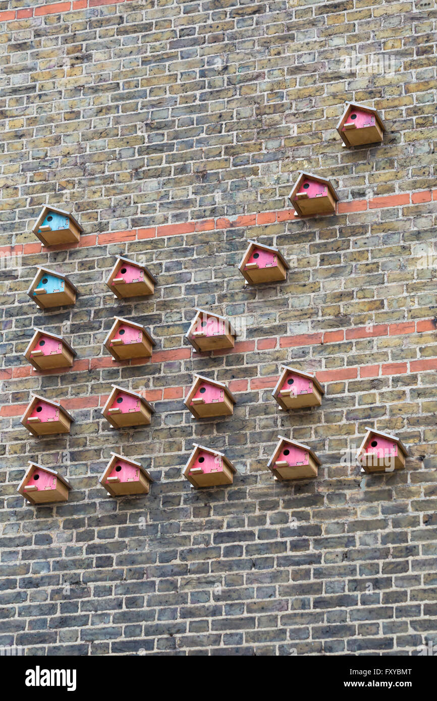 Bird boxes arranged in shape of arrow on side of building at Waterloo, London in April Stock Photo