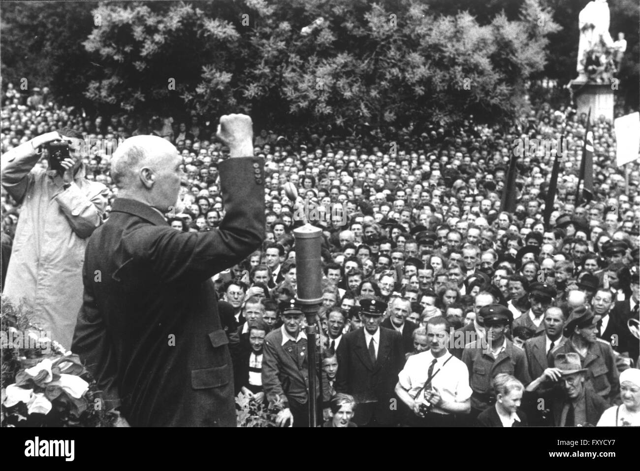 Seitz-Begrüßung, September 1945: Seitz vor Mikrophon spricht mit erhobener rechter Faust zu großer Menschenmenge am Rathausplatz Stock Photo