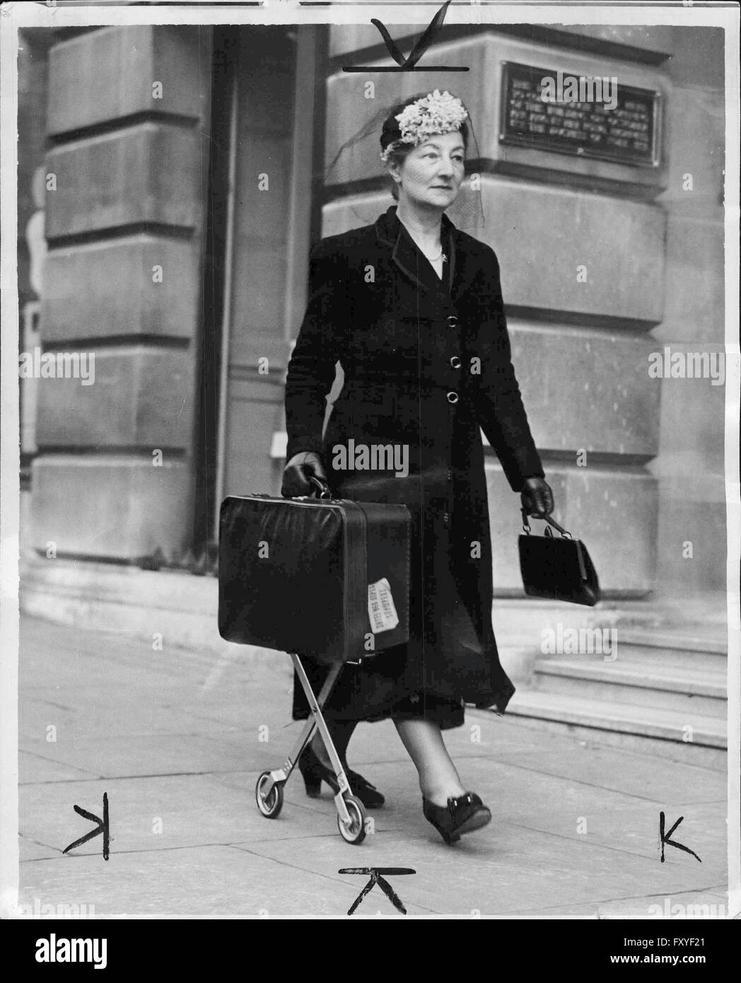 Frau auf der Straße mit Koffer auf einem Rad-Gestell Stock Photo