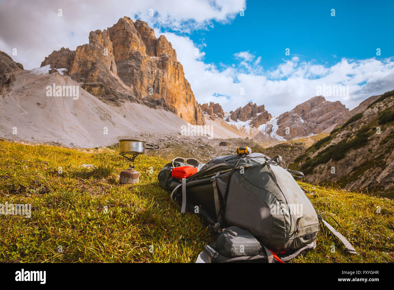 Camping gas, backpack and tourist equipment on Alps background Stock Photo