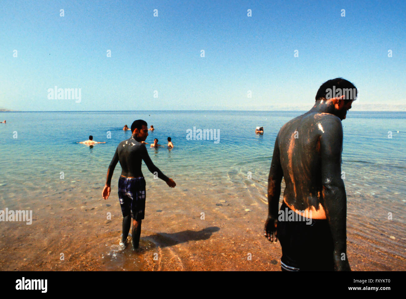 People covered with mud and swimming at the dead sea, Jordan Stock